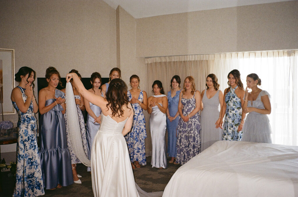 A bride showing here dress to her bridesmaids